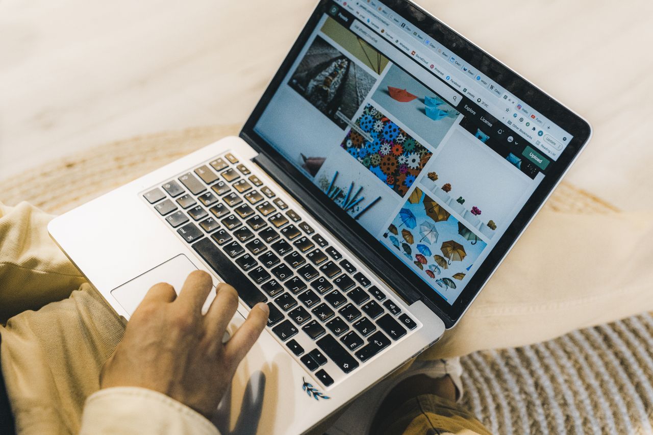 gallery-02 A person browsing stock photo websites on a laptop. Freelance work in a comfortable setting.